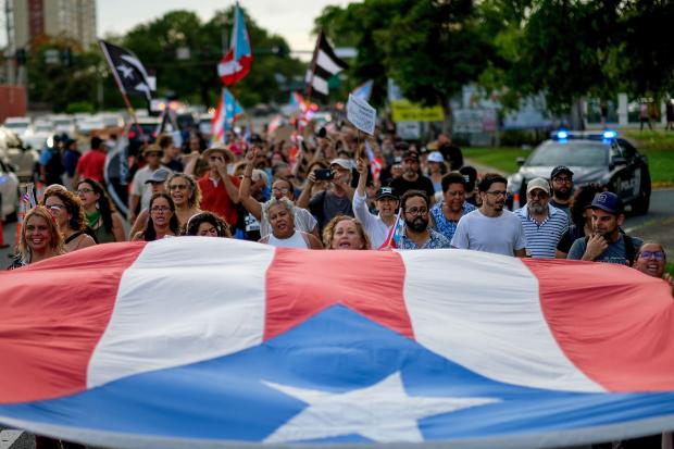 People march in protest in San Juan on July 29
