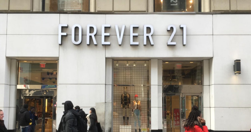 NEW YORK CITY - 1 FEBRUARY 2017: African American woman in a red jacket walks in front of Forever 21 retail store on 34th Street near 6th Avenue in Midtown Manhattan. Woman talks on her mobile phone.
