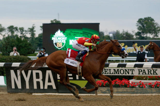 crosses the finish line to win the 150th running of the Belmont Stakes at Belmont Park on June 9