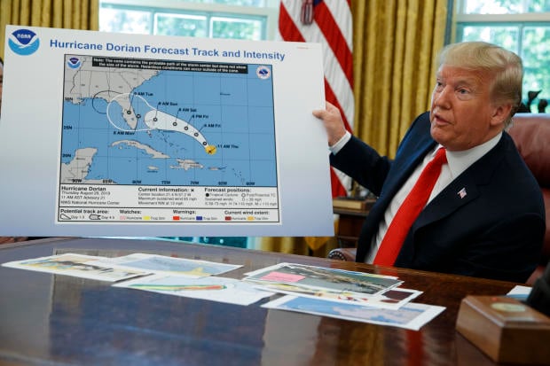 President Donald Trump talks with reporters after receiving a briefing on Hurricane Dorian in the Oval Office of the White House