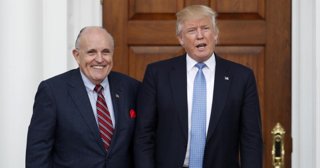 President-elect Donald Trump calls out to media as he and former New York Mayor Rudy Giuliani pose for photographs as Giuliani arrives at the Trump National Golf Club Bedminster clubhouse