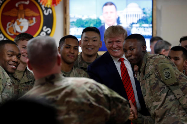 U.S. President Donald Trump takes a photo with U.S. troops during a surprise visit at Bagram Air Base in Afghanistan