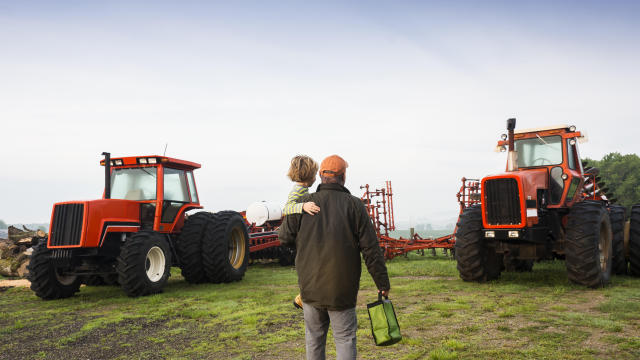 Farmer, son and tractors early in the morning 