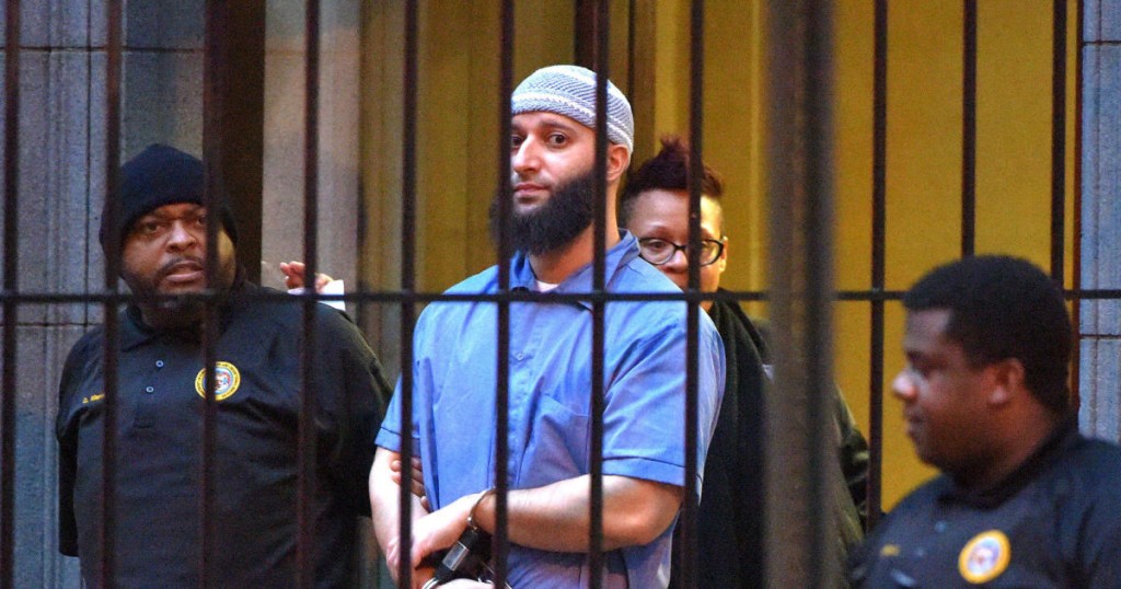 Officials escort "Serial" podcast subject Adnan Syed from the courthouse following the completion of the first day of hearings for a retrial in Baltimore on Wednesday