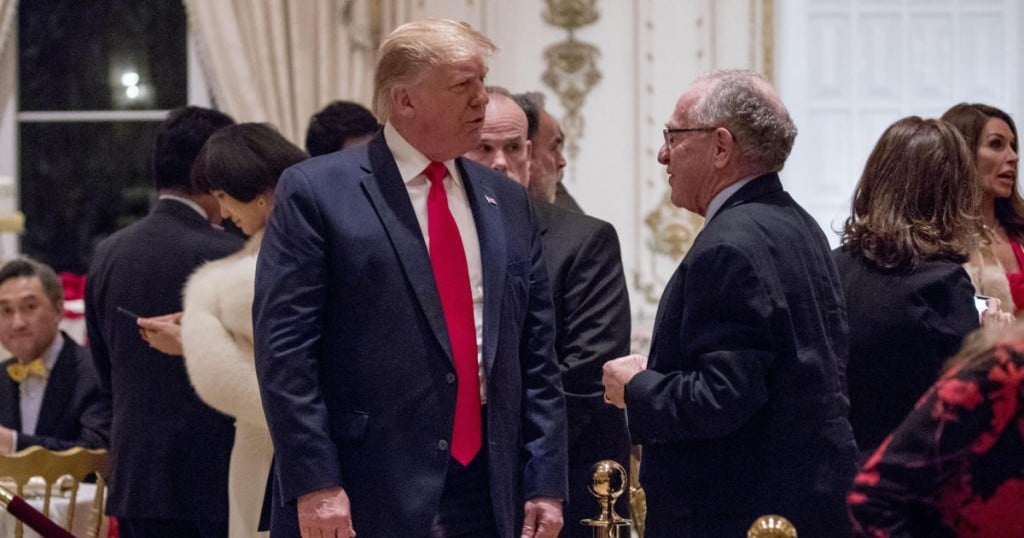 President Donald Trump speaks to attorney Alan Dershowitz