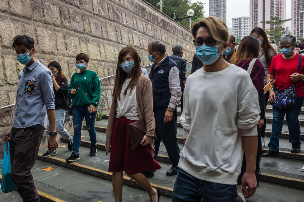 People wear masks after visiting Wong Tai Sin temple on the first day of the Lunar New Year of the Rat in Hong Kong on January 25
