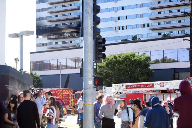 People stand outside the building after a fire on January 29
