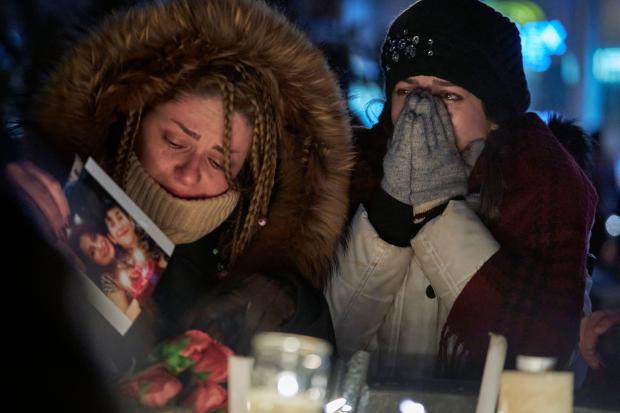 Mourners weep during a vigil for the victims of Ukrainian Airlines flight 752 which crashed in Iran during a vigil at Mel Lastman Square in Toronto