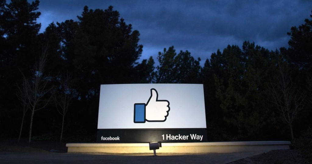 TOPSHOT - A lit sign is seen at the entrance to Facebook's corporate headquarters location in Menlo Park