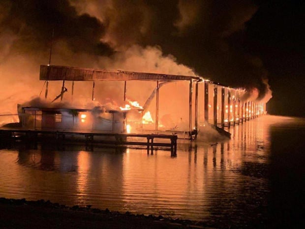 A row of boats are engulfed in flames after catching fire at the marina in Scottsboro