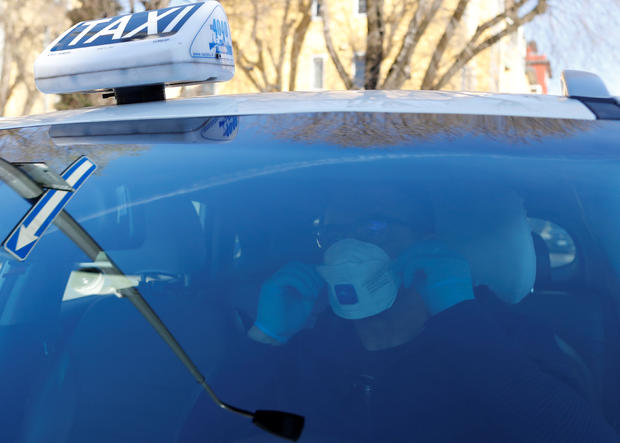 Seminario, a taxi driver in Milan, wears a protective mask 