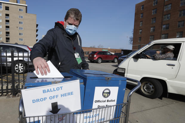 A Cuyahoga County Board of Elections worker drops a ballot in the box outside the Cuyahoga County Board of Elections during Ohio's primary Tuesday