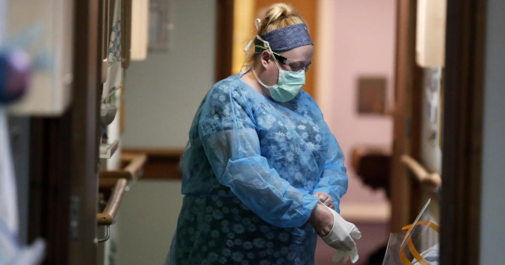 A nurse puts on PPE (personal protective equipment) at the Wren Hall care home in Nottingham