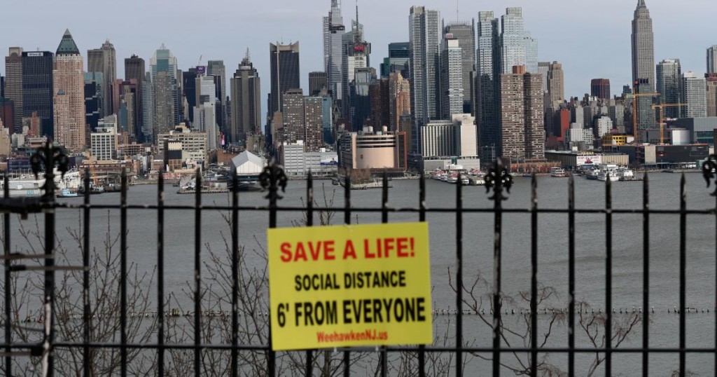 A sign hangs in a park overlooking the Manhattan skyline on April 2