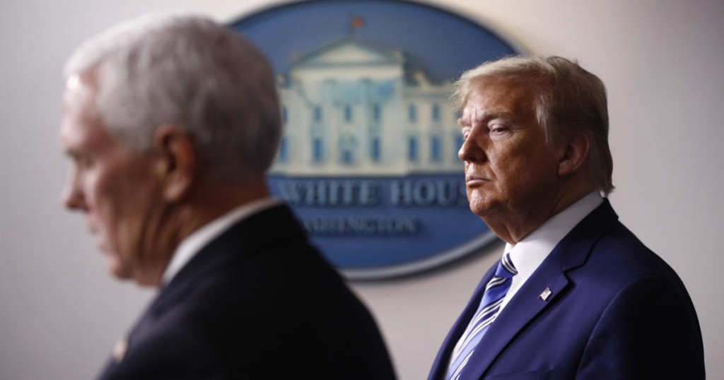 President Donald Trump listens as Vice President Mike Pence speaks during a coronavirus task force briefing at the White House