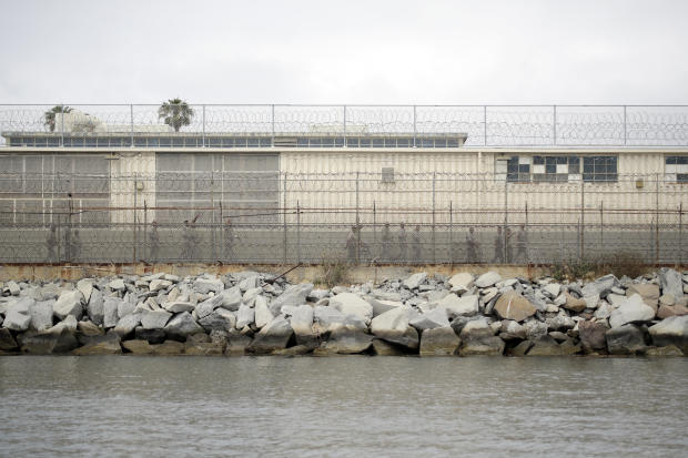 Inmates walks along a fence at the Terminal Island Federal Correctional Institution Wednesday