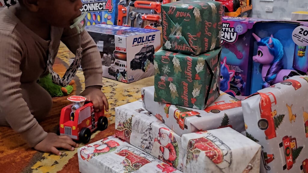 Closeup Of Christmas Presents As Kid Plays With Truck