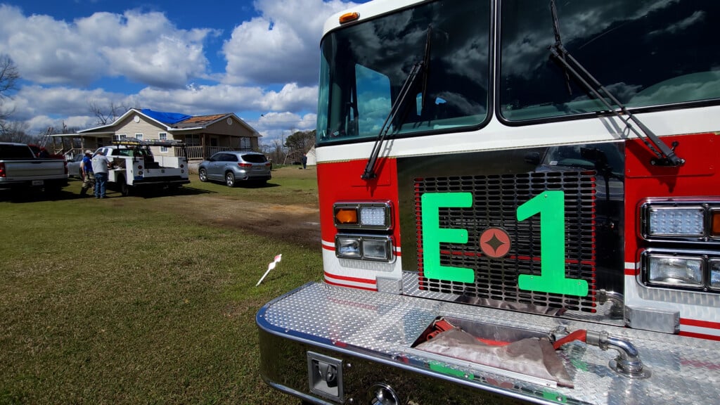 Firetruck With Storm Damaged House In The Background