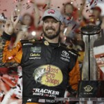 Martin Truex Jr. poses with the trophy in Victory Lane after winning the NASCAR Cup Series auto race at Charlotte Motor Speedway in Concord, N.C., Sunday, May 26, 2019.