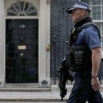 An armed police officer walks past the entrance of 10 Downing Street