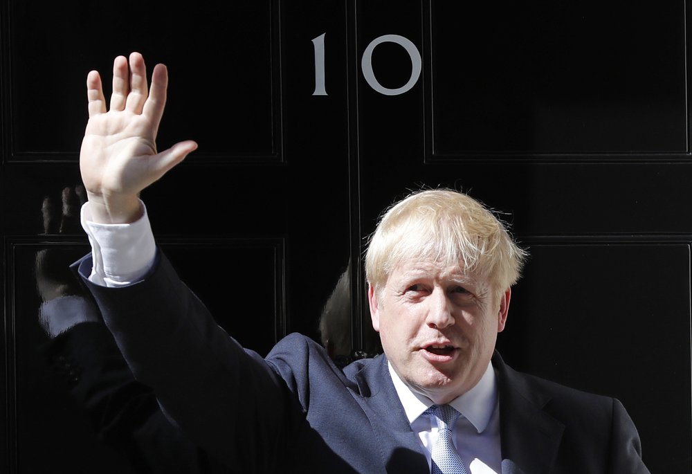 Britain's Prime Minister Boris Johnson waves from the steps outside 10 Downing Street in London