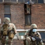 A Hostel Dweller Watches On The South African National Defense Forces Take Positions Ouside The Hostel In A Densely Populated Alexandra Township East Of Johannesburg, South Africa
