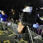 Customers Wearing Protective Masks And Gloves Wait In Line