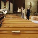 Don Marcello Crotti, Left, Blesses The Coffins With Don Mario Carminati In The San Giuseppe Church In Seriate, Italy, Saturday, March 28, 2020.