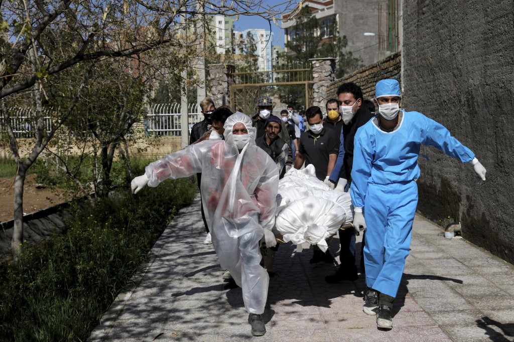 People Wearing Protective Clothing Carry The Body Of A Victim Who Died After Being Infected With The New Coronavirus At A Cemetery Just Outside Tehran, Iran, March 30, 2020.