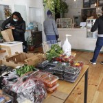 A Customer Bags Her Groceries As Others Wait To Pay After Shopping For Fresh Produce