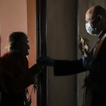 A Priest Blesses An Elderly Woman After Offering Her Willow Branches, An Orthodox Palm Sunday Tradition, In Bucharest, Romania