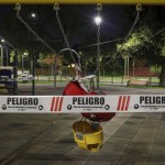 A Swing Set At A Public Playground Area Is Closed With Security Tape That Reads In Spanish