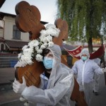 A Volunteer Wearing Protective Gear Carries A Cross While Walking Around A Church Along With Priests During The Orthodox Good Friday Religious Service In Bucharest Romania