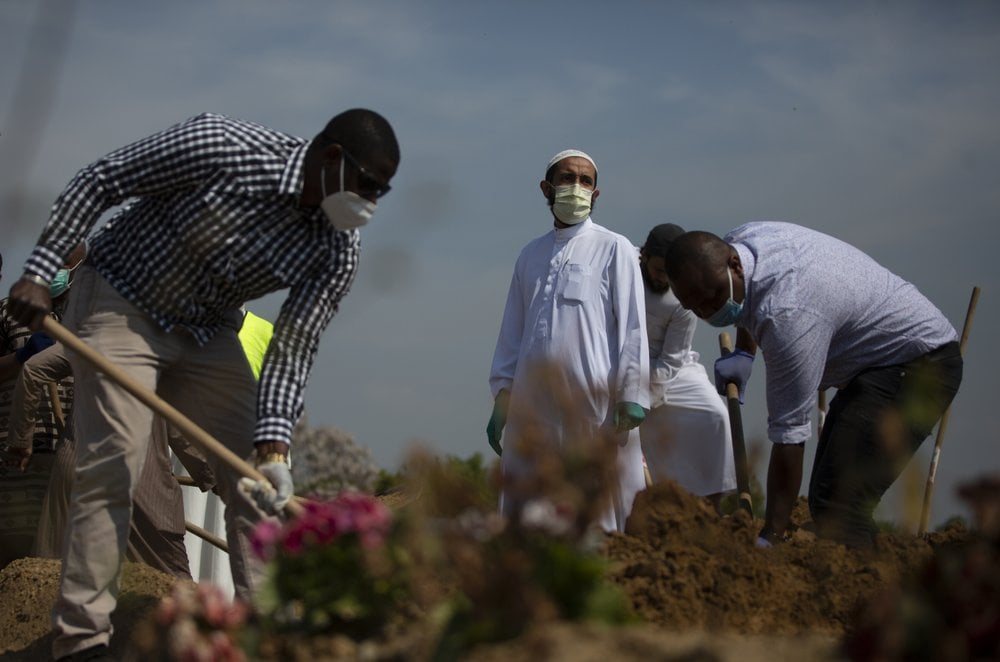 Mourners Shovel Dirt Onto The Grave Of A Guinean Man, Who Died Of Covid 19