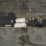 Workers Bury Bodies In A Trench On Hart Island, April 9, 2020, In The Bronx Borough Of New York