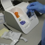 File Frame Grab From Video, A Lab Technician Dips A Sample Into The Abbott Laboratories Id Now Testing Machine At The Detroit Health Center In Detroit.