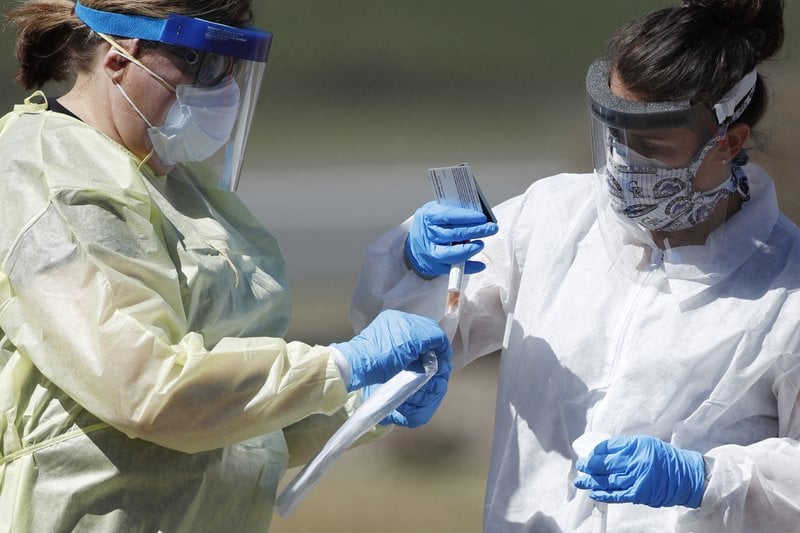 Medical Technicians Handle A Vial Containing A Nasal Swab At A Drive Thru Testing Site In Wheat Ridge, Colo
