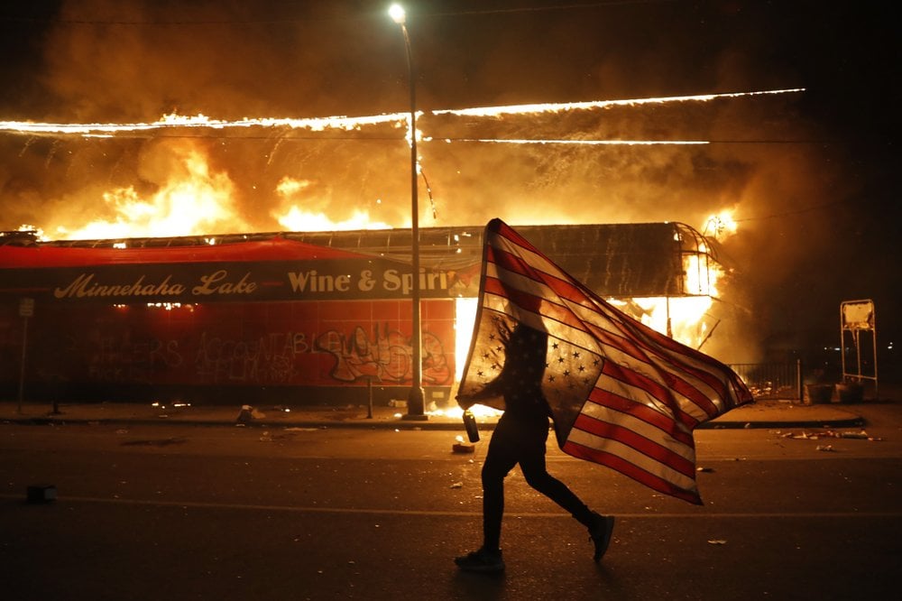 A Protester Carries A U.s. Flag Upside, A Sign Of Distress, Next To A Burning Building Thursday, May 28