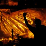 A Protester Gestures In Front Of The Burning 3rd Precinct Building Of The