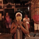 In This Thursday, April 23, 2020 Photo, A Woman Wearing A Mask As A Precaution Against The Spread Of The New Coronavirus, Prays Illuminated By A Street Lamp Outside The Closed Saint George Church,