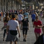 People Exercises In A Seafront Promenade In This Photo Taken With A Telephoto Lens In Barcelona, Spain
