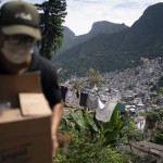 Volunteer Carries A Package With Soap And Detergent To Be Distributed To Residents In An Effort To Curb The Spread Of The New Coronavirus