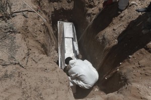 Worker Wearing Protection Suit Buries A Coffin In Ciudad Juarez Mexico