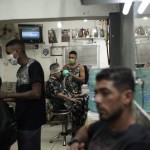 Wearing Protective Face Masks As A Precaution Against The Spread Of The New Coronavirus, Attend To Clients In A Barbershop In The Mandela Favela Of Rio De Janeiro, Brazil