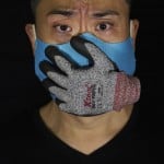 Edmond Kok, A Hong Kong Theater Costume Designer And Actor, Wearing A Face Mask Designed With A Stuffed Glove Stuck On It, Representing A Hand Over His Mouth, Looking Scared, In Hong Kong