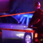 A Thurston County Sheriff's Deputy Wears A Mask As He Stands Near Crime Scene Tape