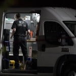 A Washington State Patrol Crime Lab Worker Stands In A Van