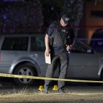 A Washington State Patrol Official Walks Near Evidence Markers And A Car With Broken Windows 2