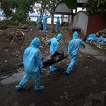 Health Workers Wearing Personal Protective Equipment Carry The Body Of A Covid 19 Victim For Cremation In Gauhati, India