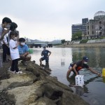 People Pray As Paper Lanterns Float Along The Motoyasu River In Front Of The Atomic Bomb Dome